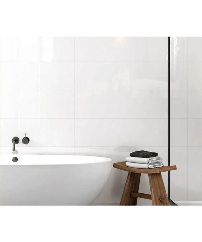 super white wall tiles modern bathroom with a freestanding bathtub and wooden stool with towels.
