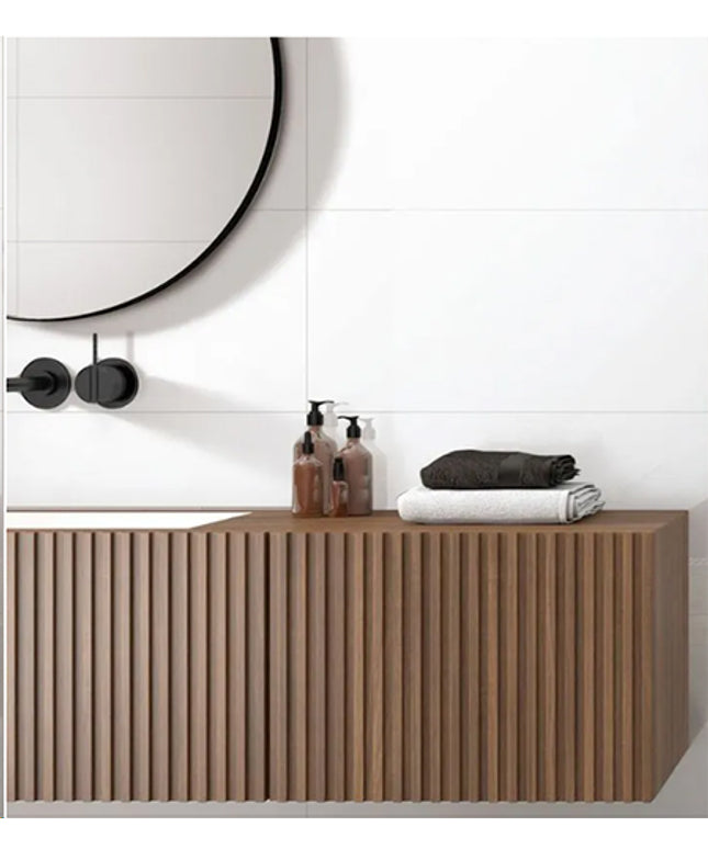 Bathroom vanity with toiletries and towels against a white tiled wall.