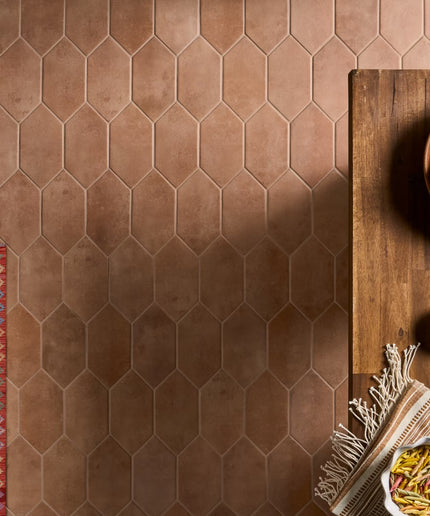 Hexagonal brown tiles on a floor with a wooden table and decorative items.