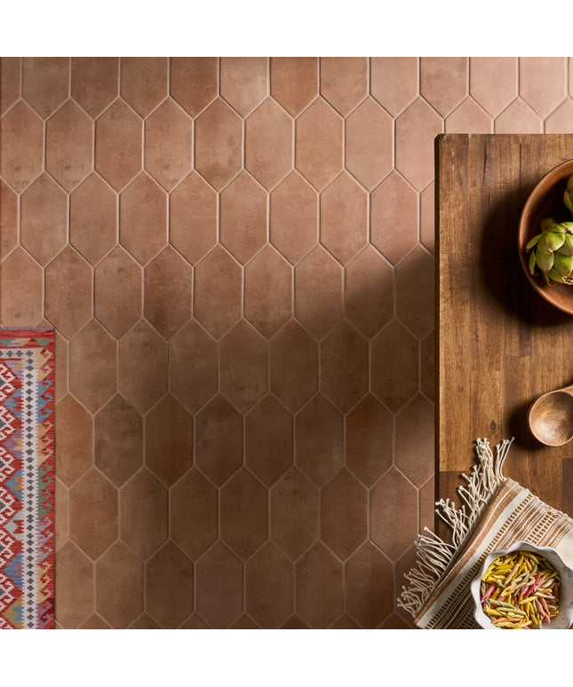 Hexagonal brown tiles on a floor with a wooden table and decorative items.