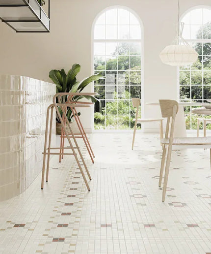Modern kitchen with white tiled floor, white cabinets, and a dining area.