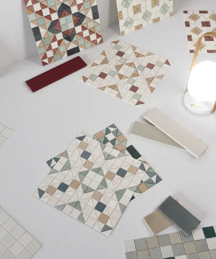 Collection of mosaic tiles with various patterns on a white surface.
