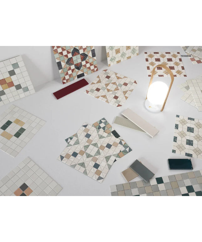 Collection of mosaic tiles with various patterns on a white surface.