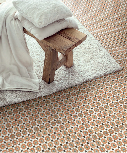 Patterned floor tiles with geometric design under a wooden bench and white rug