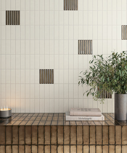 Modern interior design with green tiles, a wooden shelf, and decorative elements.