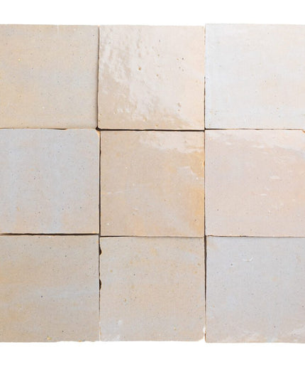 Nine square tiles in beige and white on a white background
