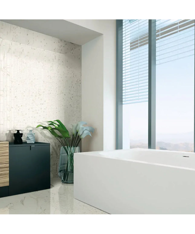Modern bathroom with Calacatta marble wall tiles, large bathtub, and natural light