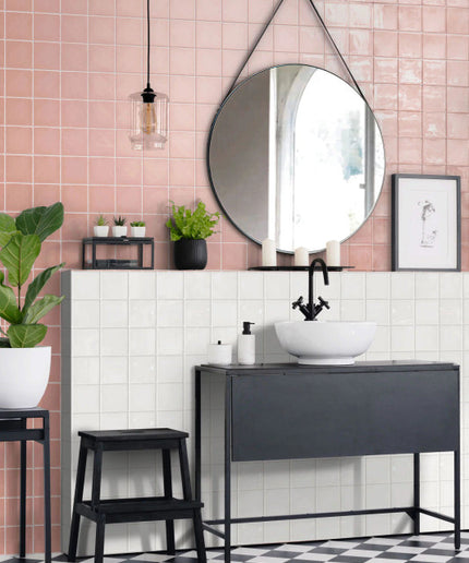 Modern bathroom with pink and white square tile backsplash, black vanity, and round mirror
