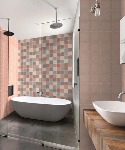 Modern bathroom with pink and beige square tiles, freestanding tub, and double sinks