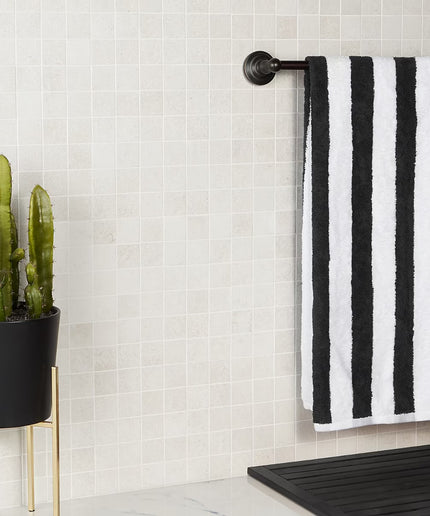Black and white striped towel hanging on a rack next to a potted cactus in a bathroom. made in the USA