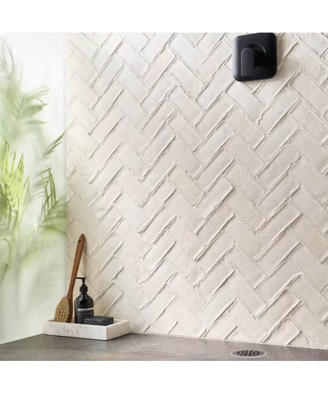 White tiled wall with a herringbone pattern in a bathroom setting.