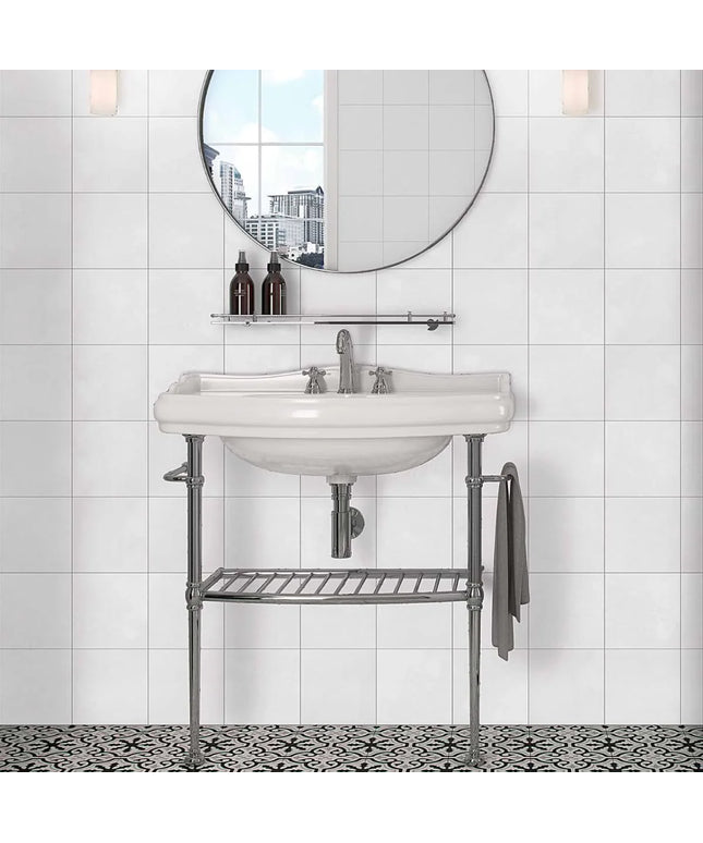Bathroom vanity with round mirror and decorative elements against a tiled wall.