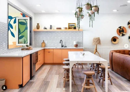 Modern kitchen with geometric black and white tile backsplash, orange cabinets, and wood stools
