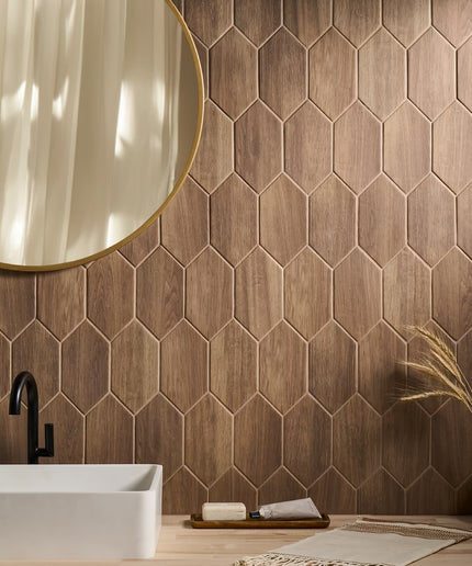 Bathroom with hexagonal wooden tiles, a white sink, and a round mirror.