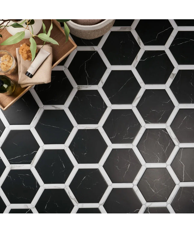 Hexagonal black and white tiles on a floor with a wooden tray and plants.