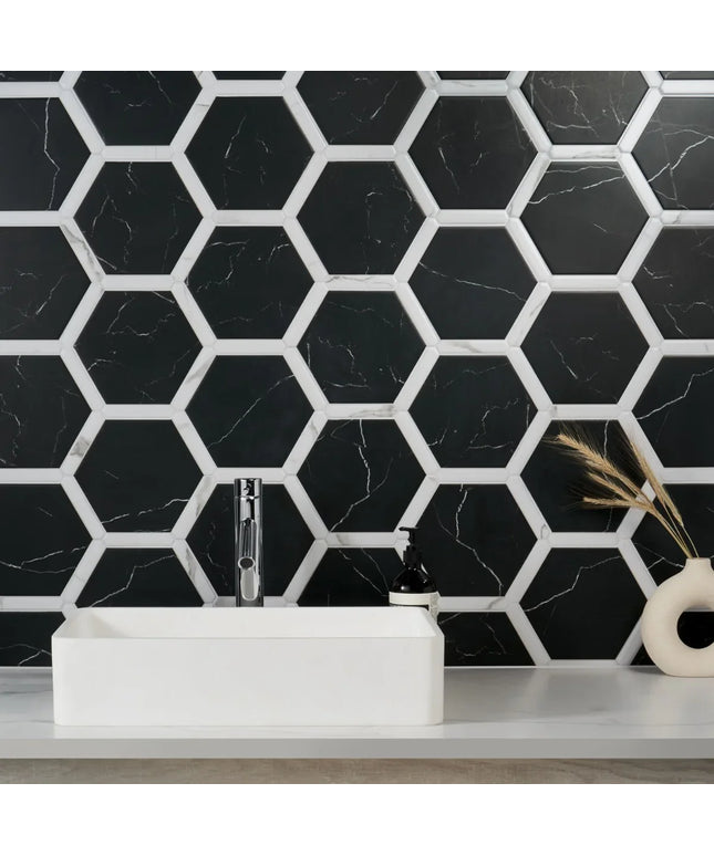 Bathroom with black hexagonal tiles on the wall, white sink, and decorative vase.