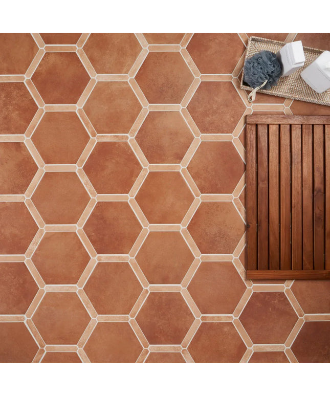 Hexagonal terracotta tiles on a floor with a wooden bench and cleaning supplies.