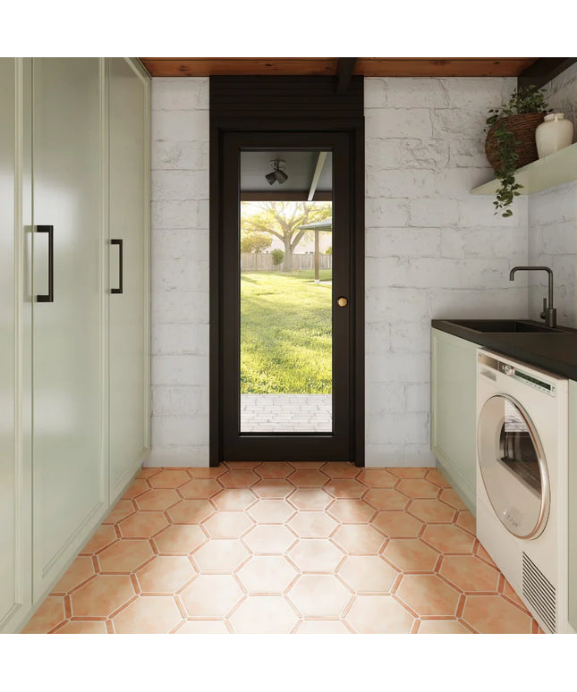 Modern laundry room with hexagonal tiles, washer, dryer, and a door leading outside.